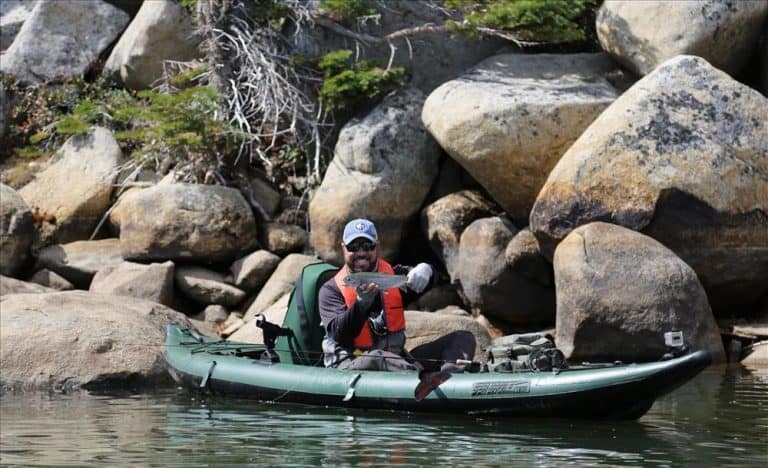 Man catching fish on inflatable kayak